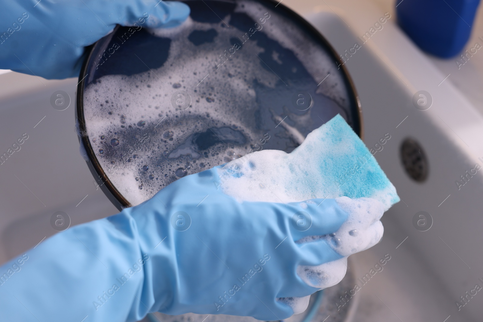 Photo of Woman washing dishes in kitchen sink, closeup