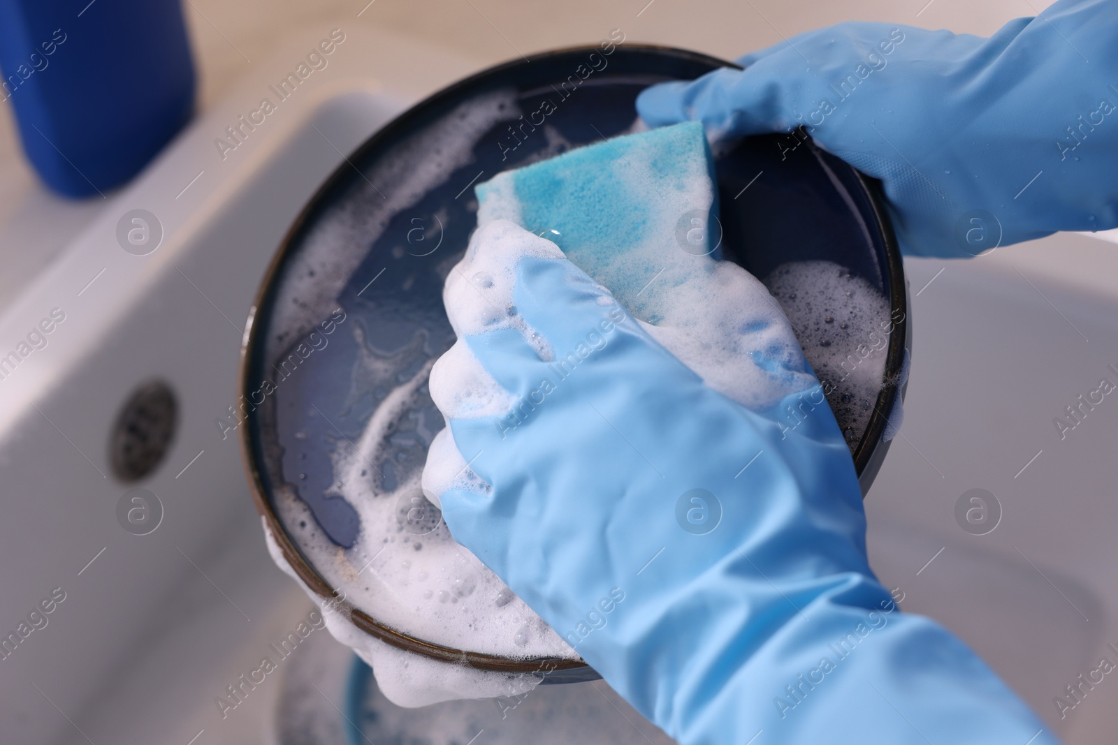 Photo of Woman washing dishes in kitchen sink, closeup