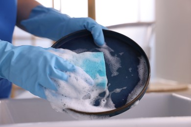 Photo of Woman washing dishes in kitchen sink, closeup