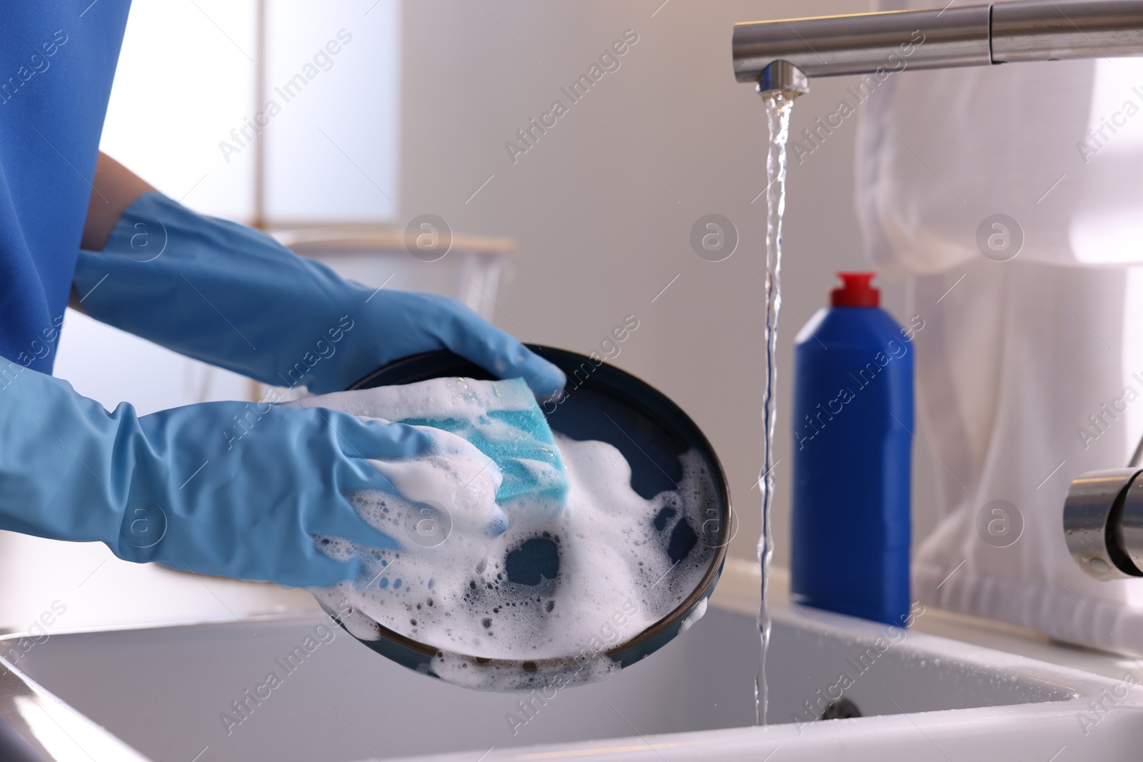 Photo of Woman washing dishes in kitchen sink, closeup