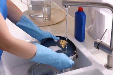 Photo of Woman washing dishes in kitchen sink, closeup