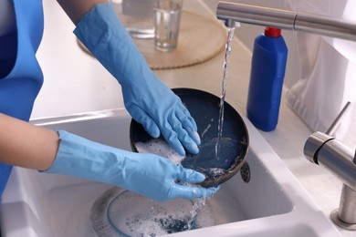 Photo of Woman washing dishes in kitchen sink, closeup