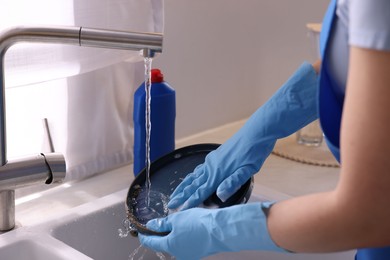 Photo of Woman washing dishes in kitchen sink, closeup