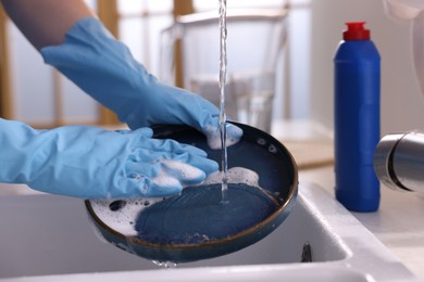 Photo of Woman washing dishes in kitchen sink, closeup