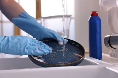 Photo of Woman washing dishes in kitchen sink, closeup