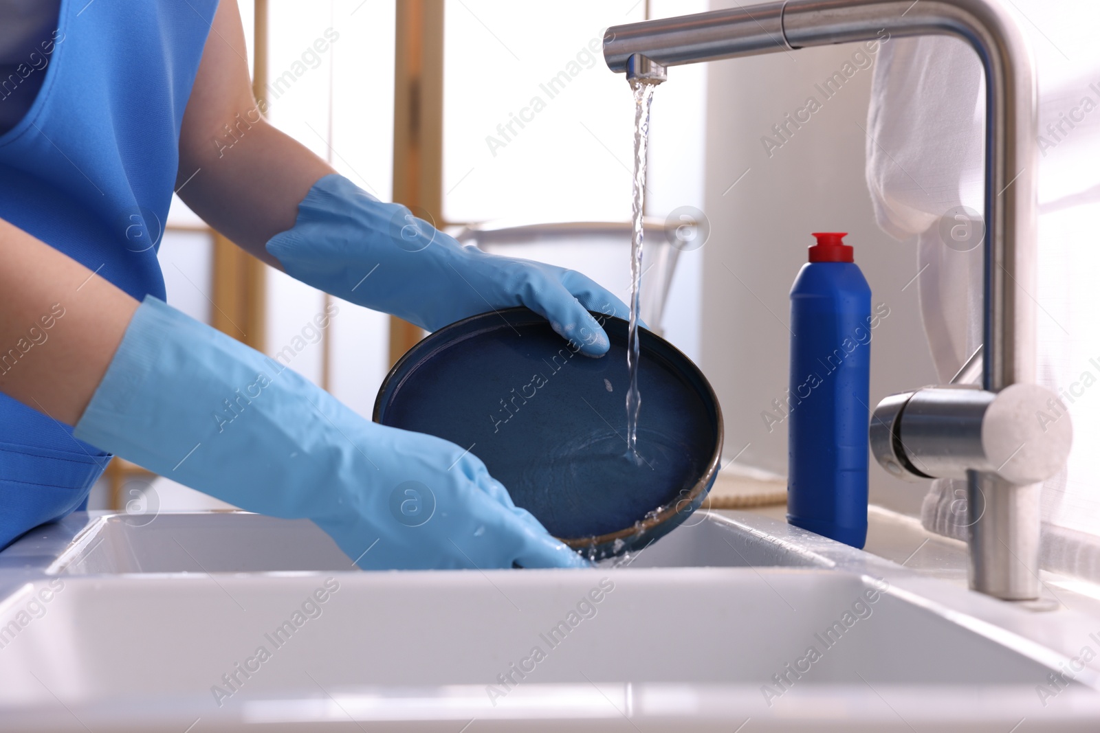 Photo of Woman washing dishes in kitchen sink, closeup