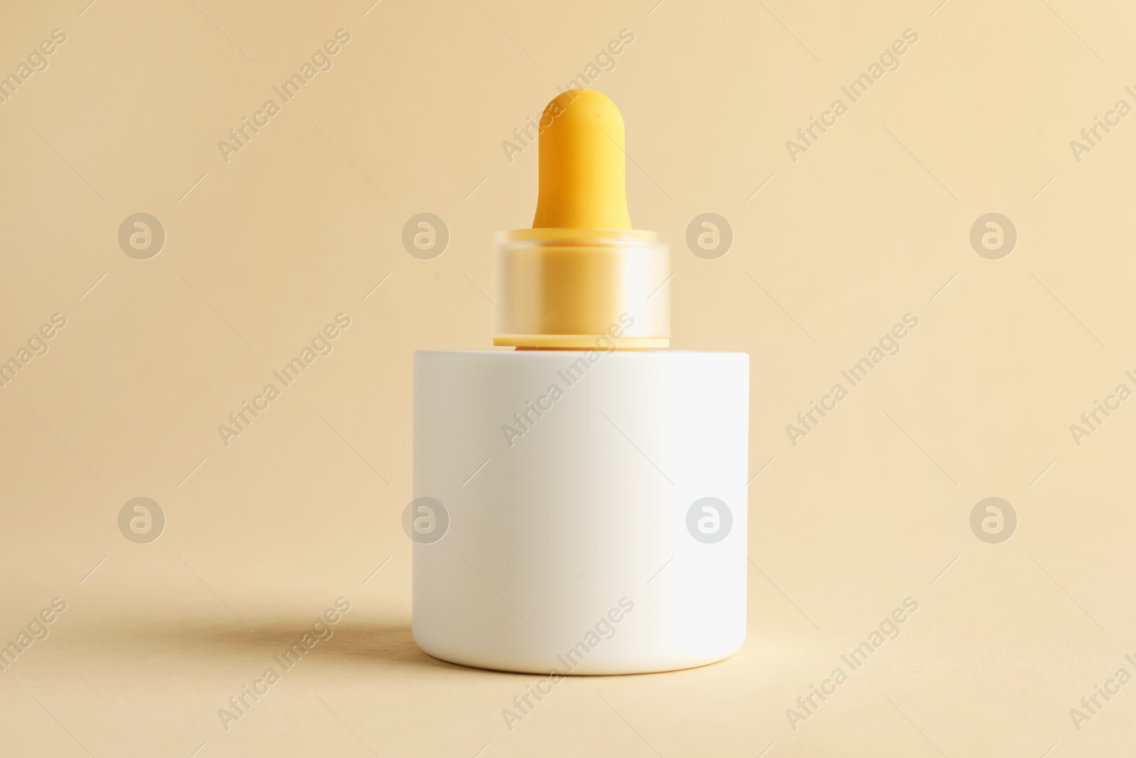 Photo of Bottle of skin care product on beige background