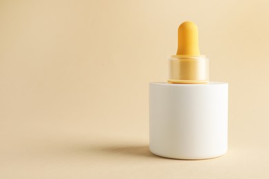 Photo of Bottle of skin care product on beige background, space for text