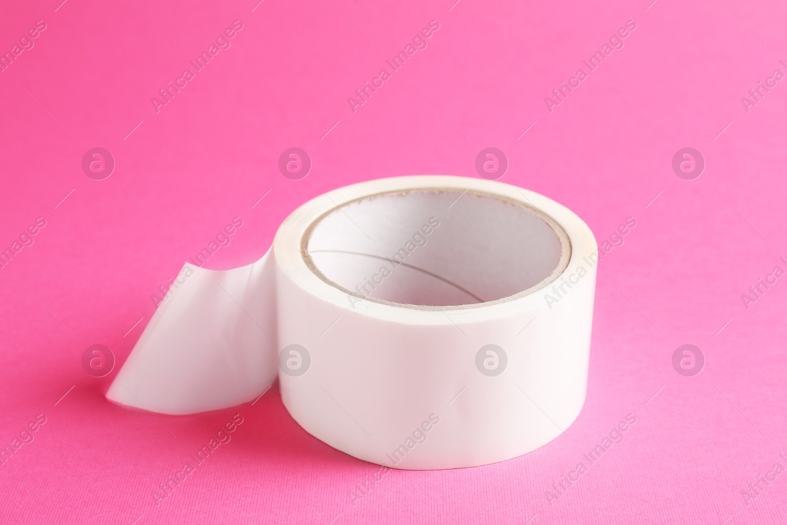 Photo of One masking tape on pink background, closeup