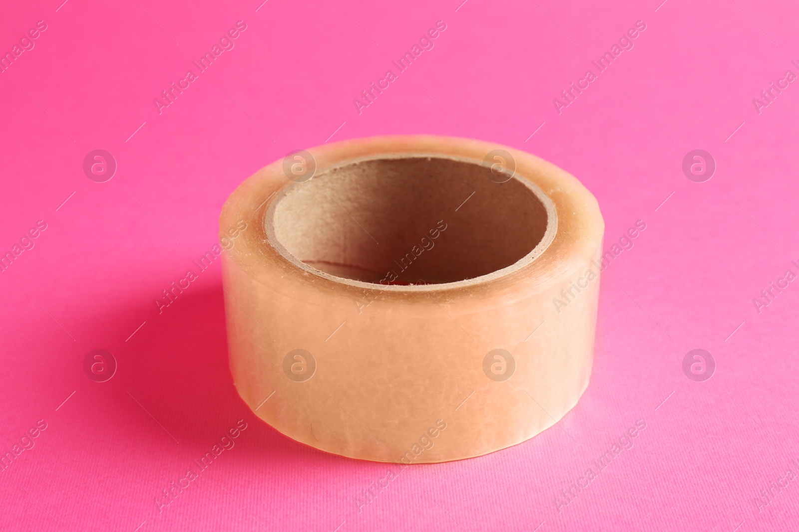 Photo of One masking tape on pink background, closeup