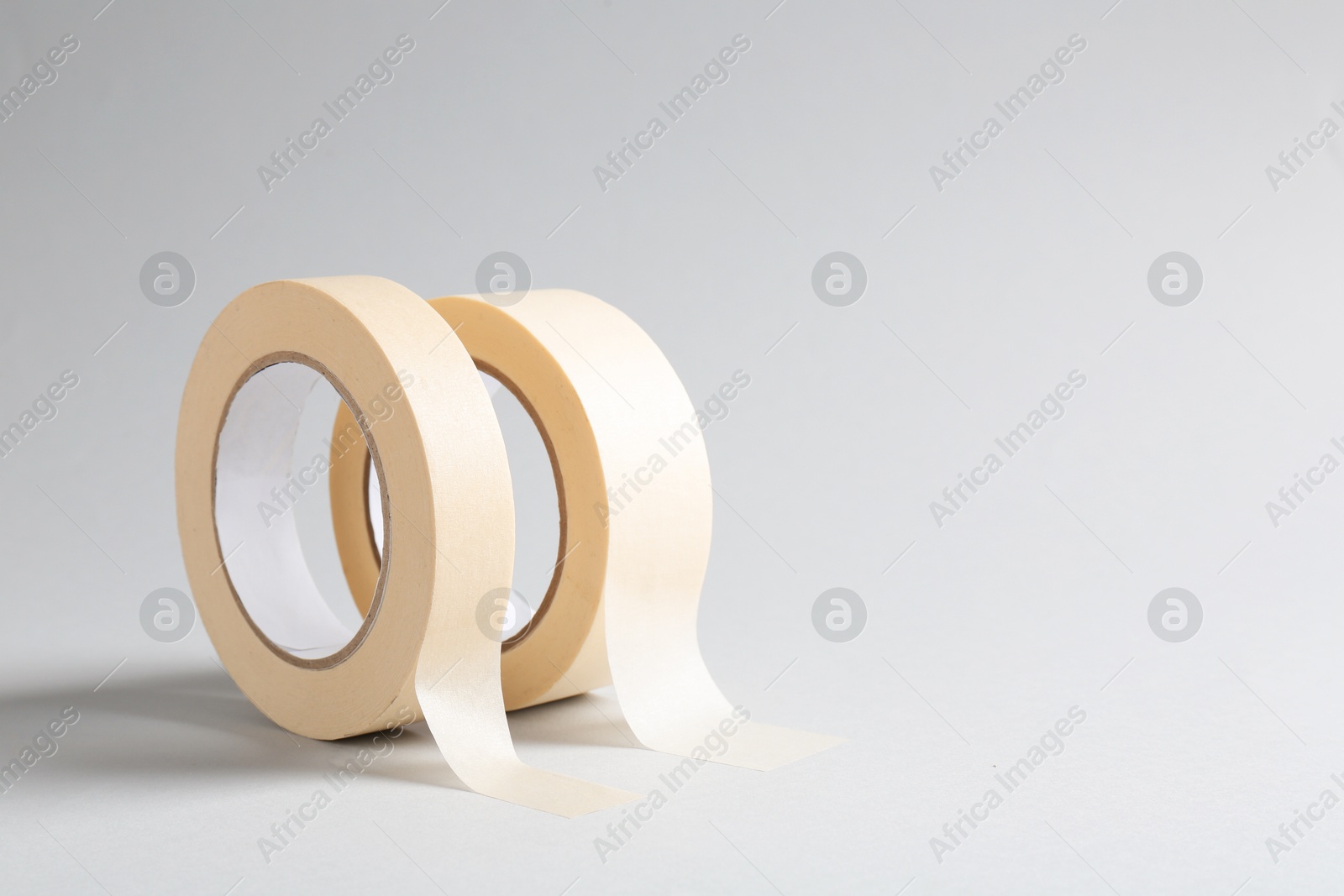 Photo of Two masking tapes on grey background, closeup. Space for text