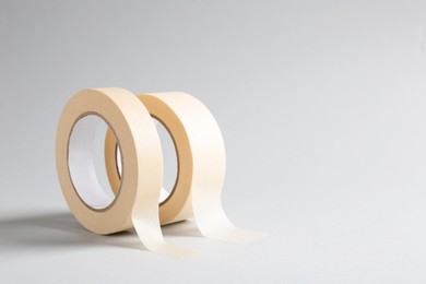 Photo of Two masking tapes on grey background, closeup. Space for text