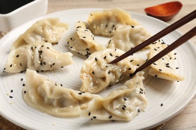 Photo of Eating tasty gyoza dumplings at table, closeup