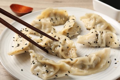 Photo of Eating tasty gyoza dumplings at table, closeup