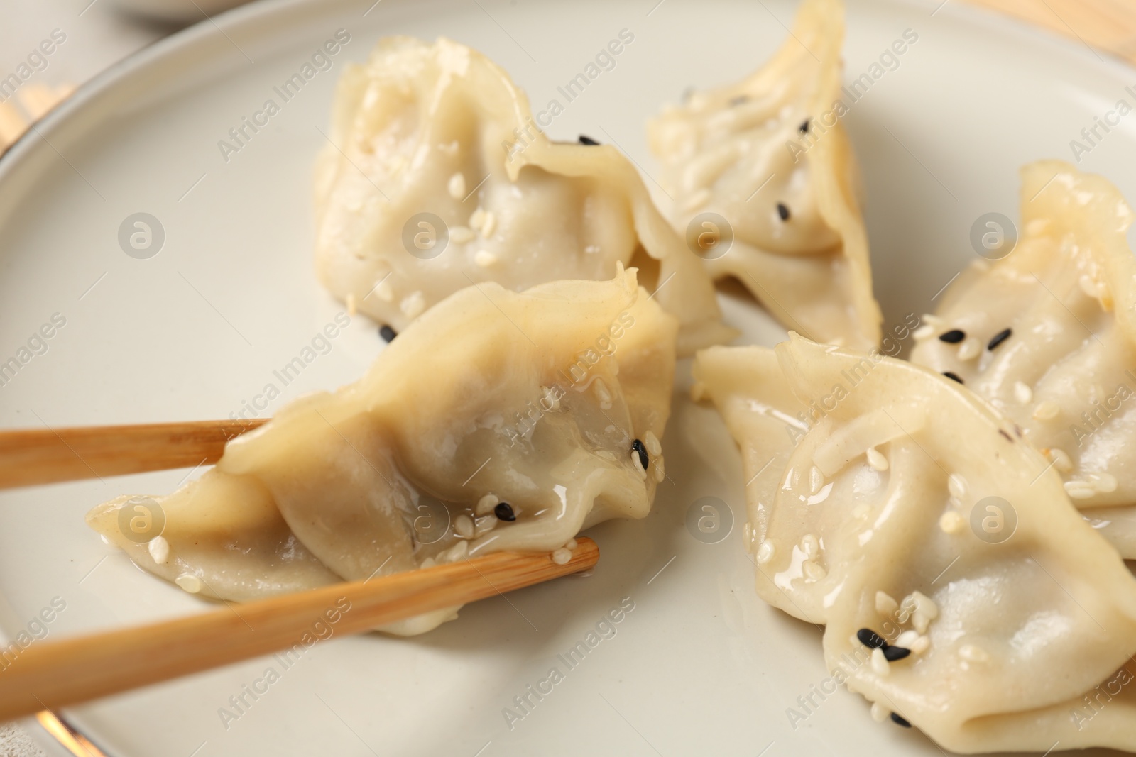 Photo of Eating tasty gyoza dumplings at table, closeup