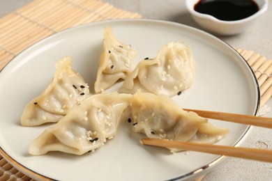 Photo of Eating tasty gyoza dumplings at table, closeup