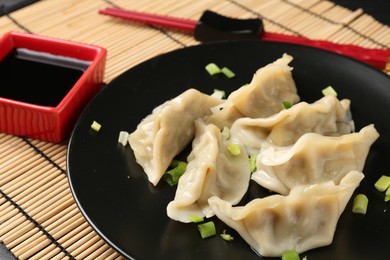 Photo of Delicious gyoza dumplings with chives served on table, closeup