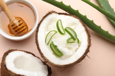 Photo of Hair treatment. Coconut, butter shavings, honey and aloe leaves on beige background, flat lay