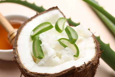 Photo of Hair treatment. Coconut, butter shavings, honey and aloe leaves on beige background, closeup