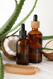 Photo of Hair treatment. Cosmetic products, comb, coconut and aloe leaves on white background