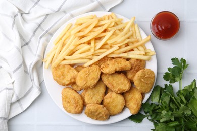 Photo of Tasty chicken nuggets and french fries with sauce on white tiled table, flat lay