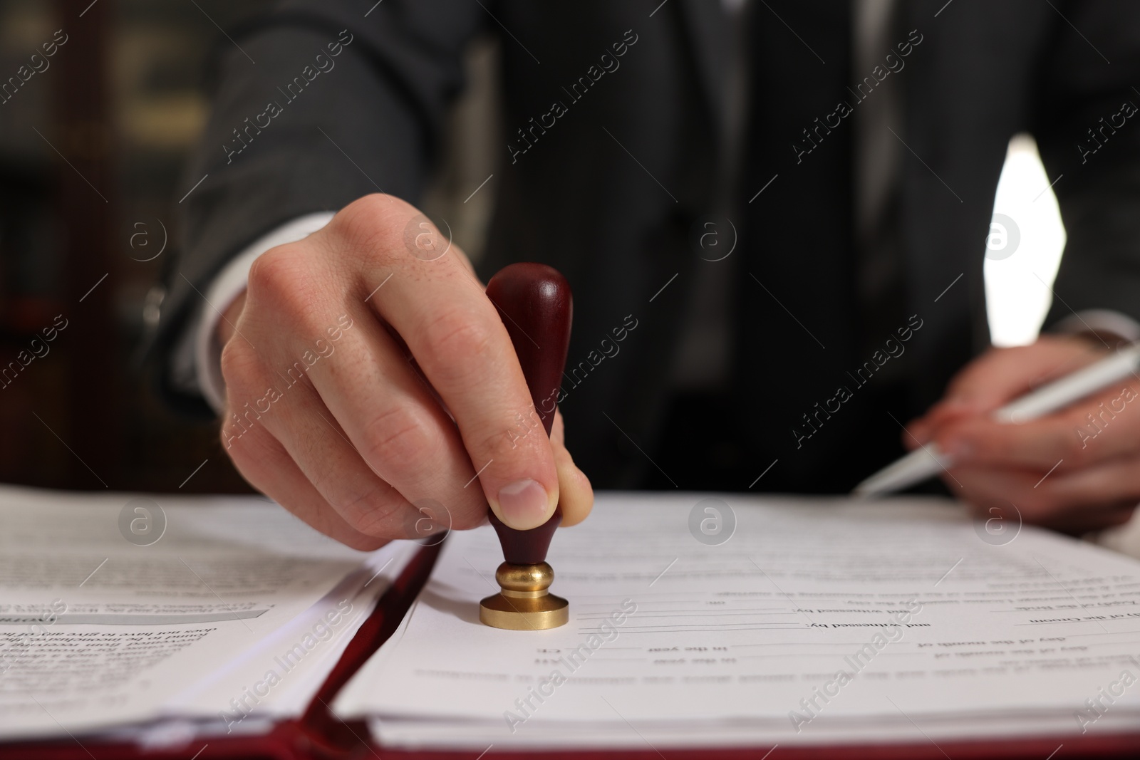 Photo of Notary stamping document in office, closeup view