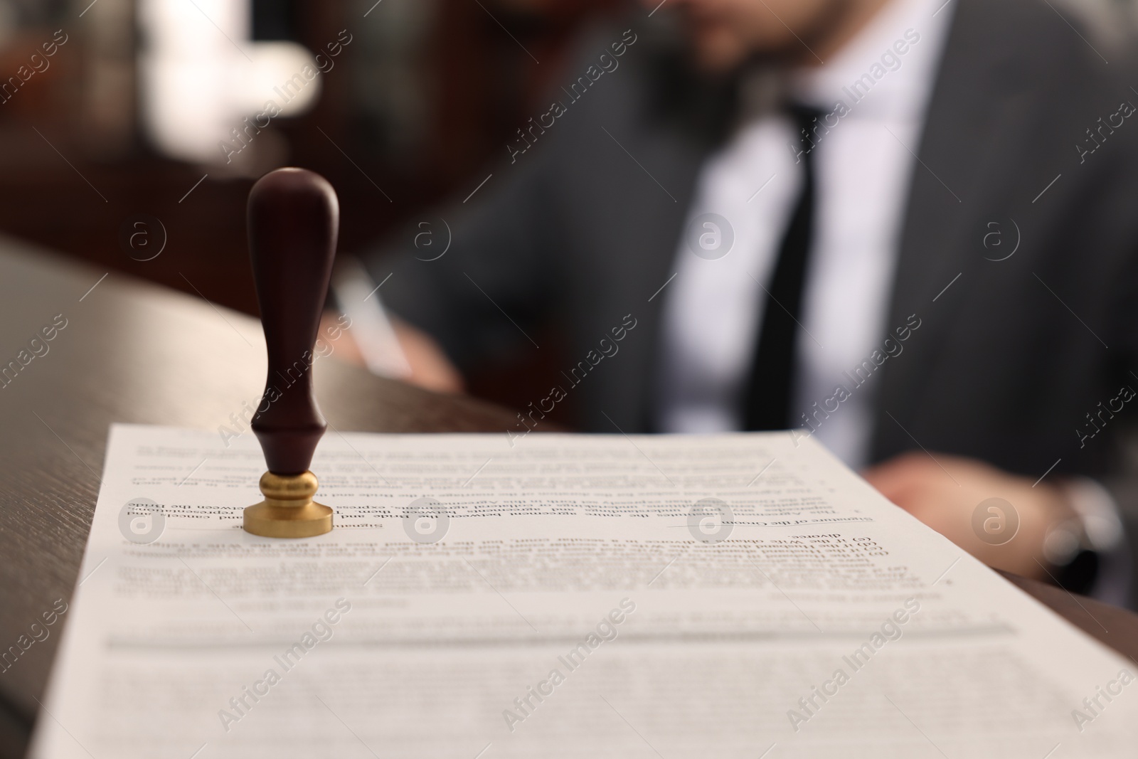 Photo of Notary working in office, focus on stamp