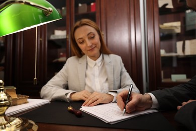 Photo of Notary working with client at table in office