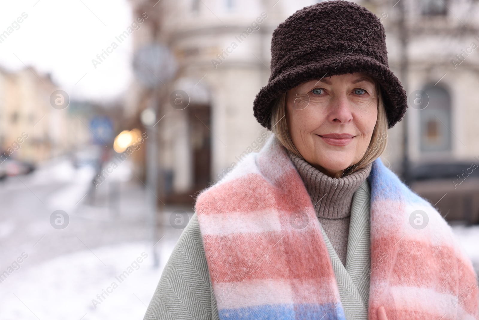 Photo of Portrait of beautiful senior woman on city street. Space for text