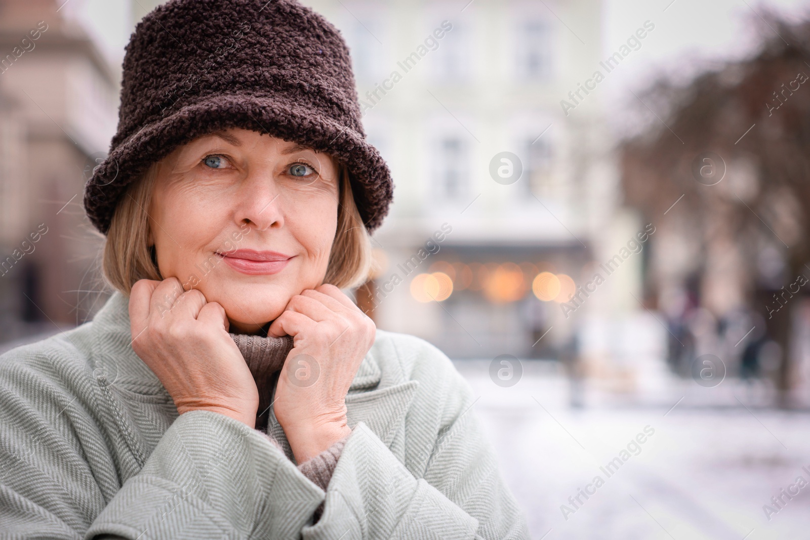 Photo of Portrait of beautiful senior woman on city street. Space for text