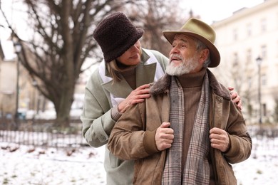 Photo of Happy senior couple on winter day. Space for text