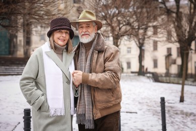 Photo of Happy senior couple on winter day. Space for text