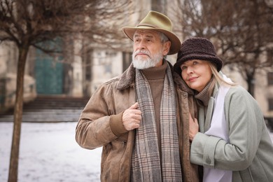 Photo of Portrait of senior couple on city street. Space for text