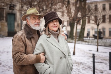 Photo of Portrait of senior couple on city street. Space for text