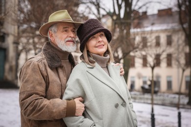 Photo of Portrait of senior couple on city street. Space for text