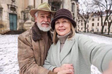 Photo of Happy senior couple taking selfie on winter day