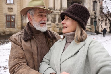 Photo of Happy senior couple taking selfie on winter day