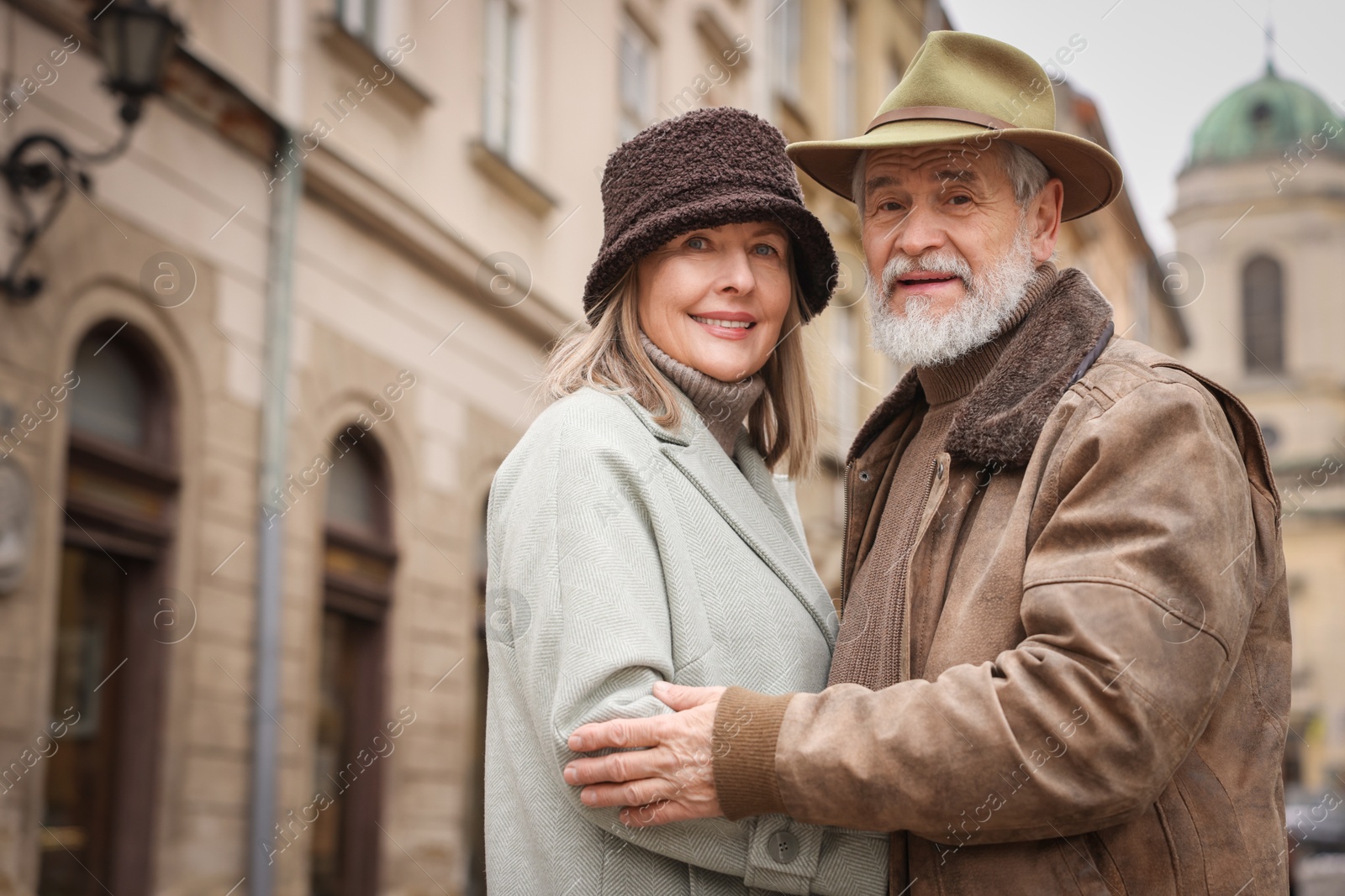 Photo of Happy senior couple on city street. Space for text