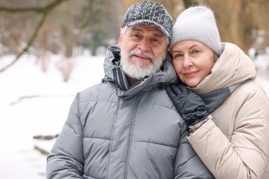 Photo of Portrait of happy senior couple at winter park. Space for text