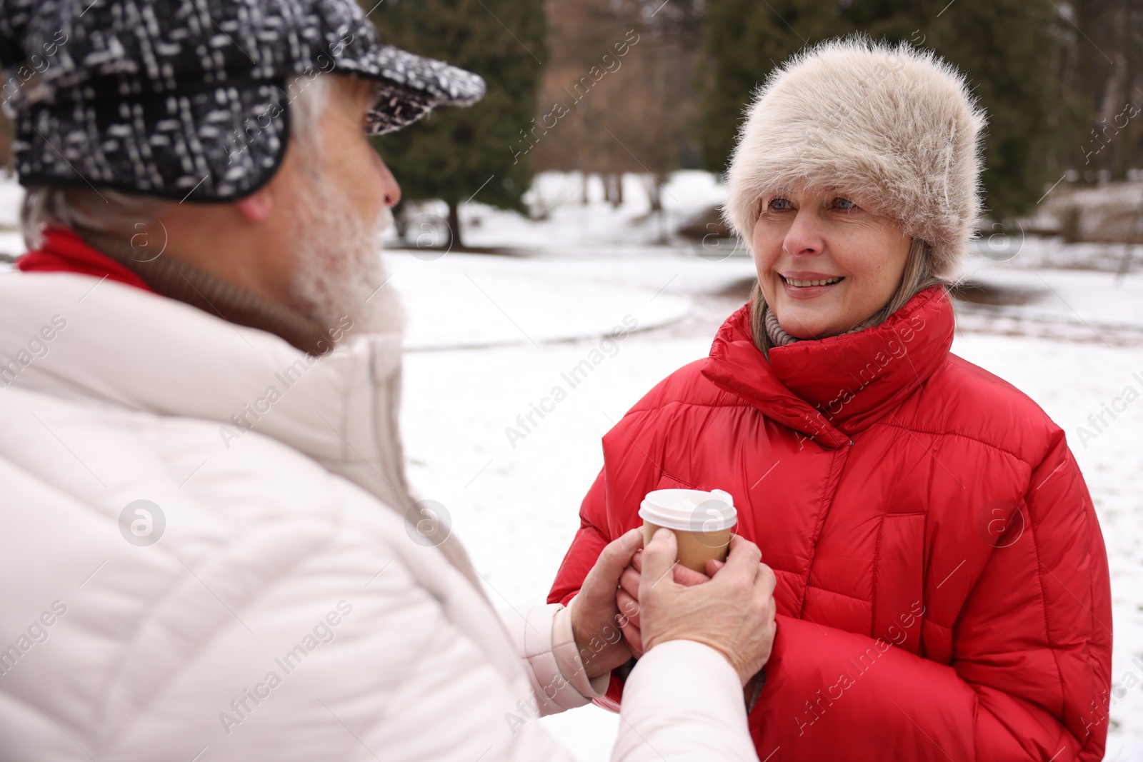 Photo of Lovely senior couple with paper cup in winter park