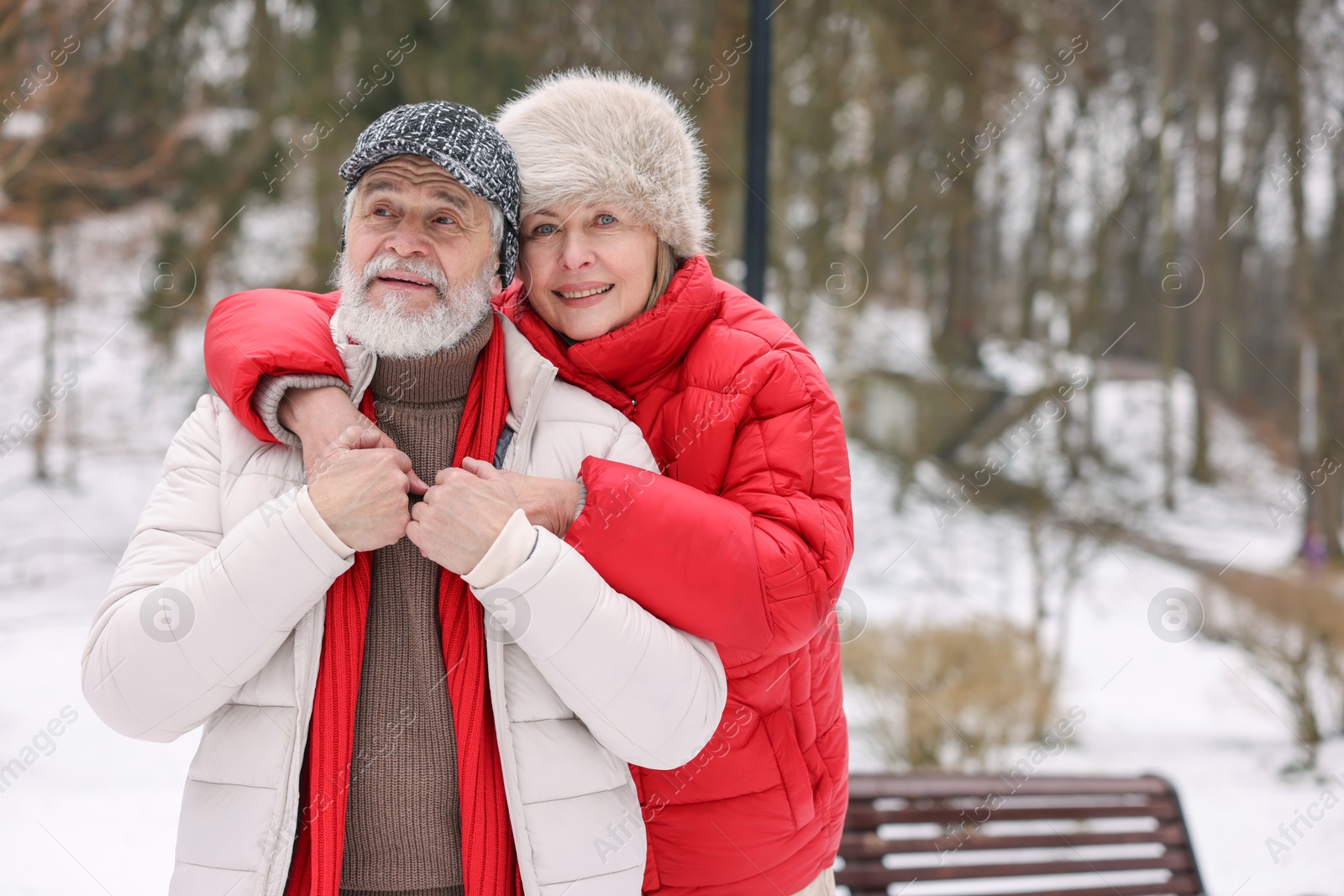 Photo of Happy senior couple at winter park. Space for text