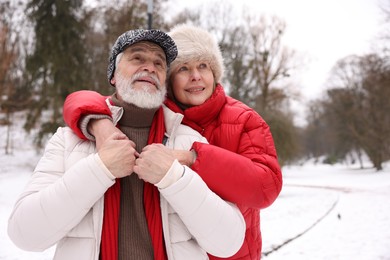 Photo of Happy senior couple at winter park. Space for text