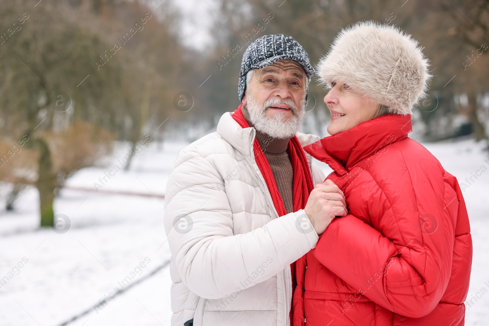 Photo of Happy senior couple at winter park. Space for text