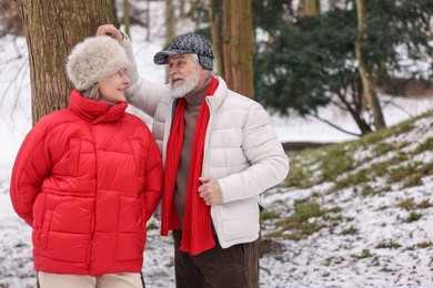 Photo of Lovely senior couple spending time together in winter park. Space for text