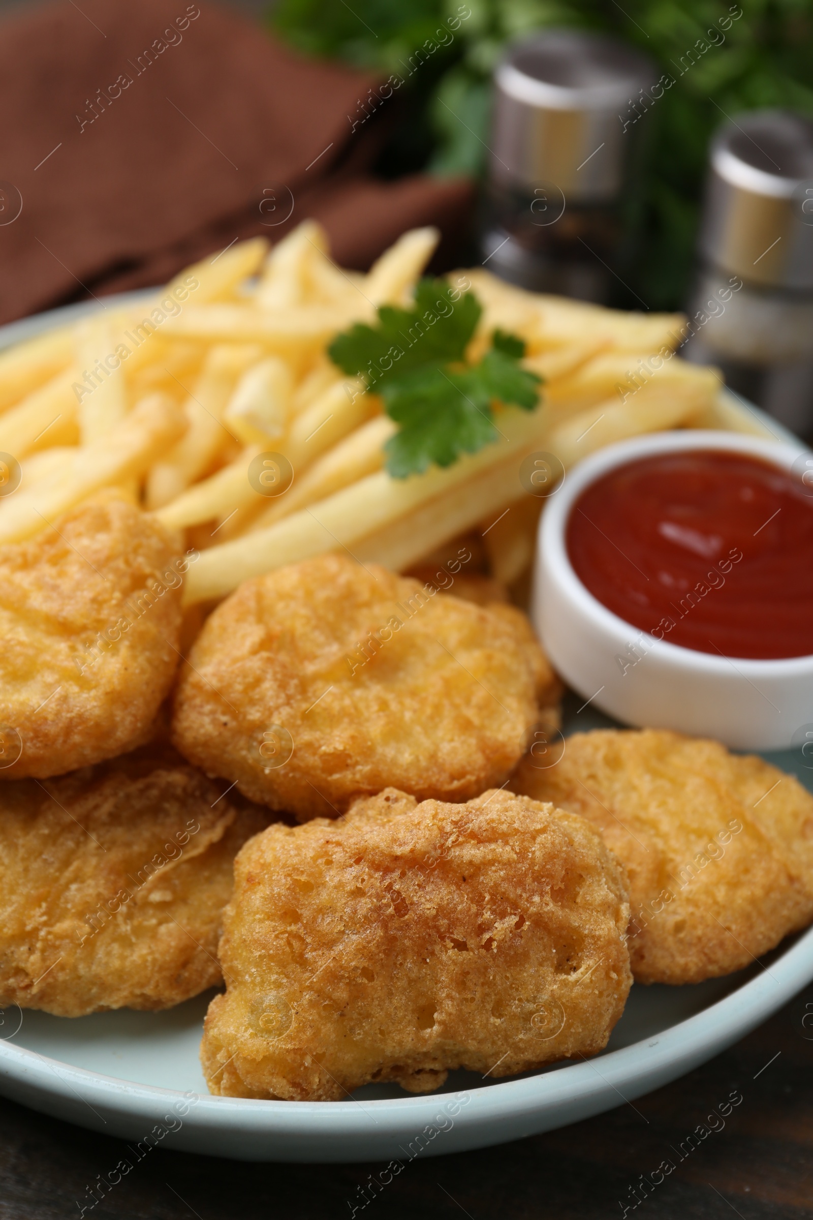 Tasty chicken nuggets and french fries with sauce on wooden table, closeup Photo of Tasty chicken nuggets and french fries with sauce on wooden table, closeup