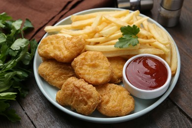 Photo of Tasty chicken nuggets and french fries with sauce on wooden table, closeup
