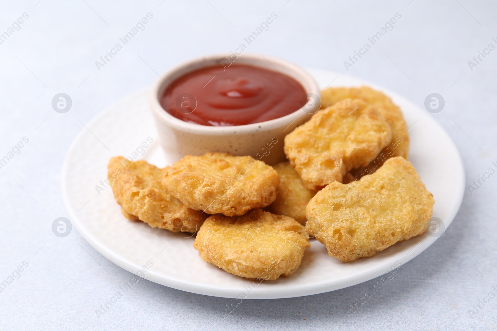 Tasty chicken nuggets with sauce on white background, closeup Photo of Tasty chicken nuggets with sauce on white background, closeup