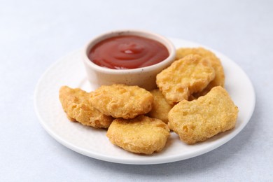 Photo of Tasty chicken nuggets with sauce on white background, closeup