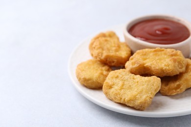 Photo of Tasty chicken nuggets with sauce on white background, closeup. Space for text
