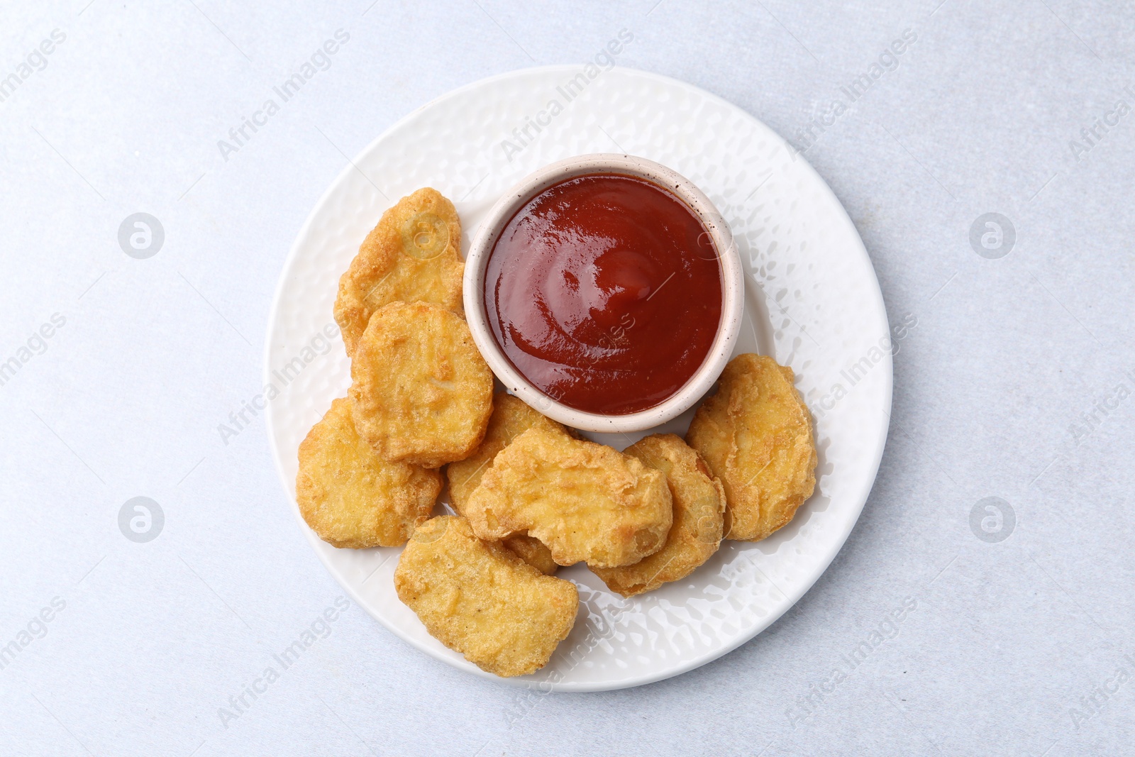 Tasty chicken nuggets with sauce on white background, top view Photo of Tasty chicken nuggets with sauce on white background, top view